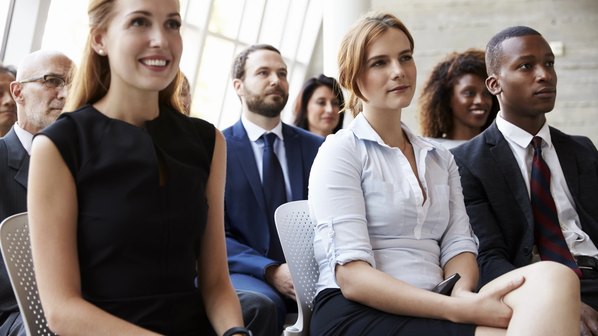 Businesspeople attentively listening at conference.